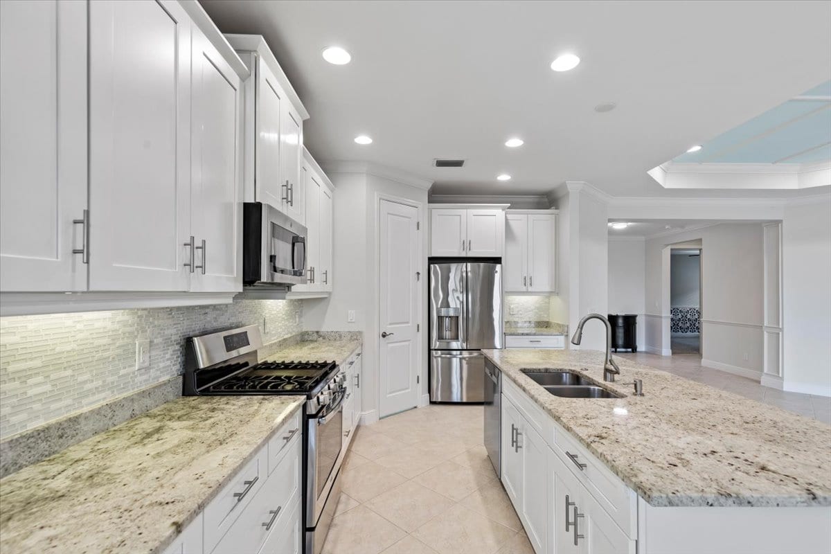 Renovated kitchen with white cabinets and granite counters